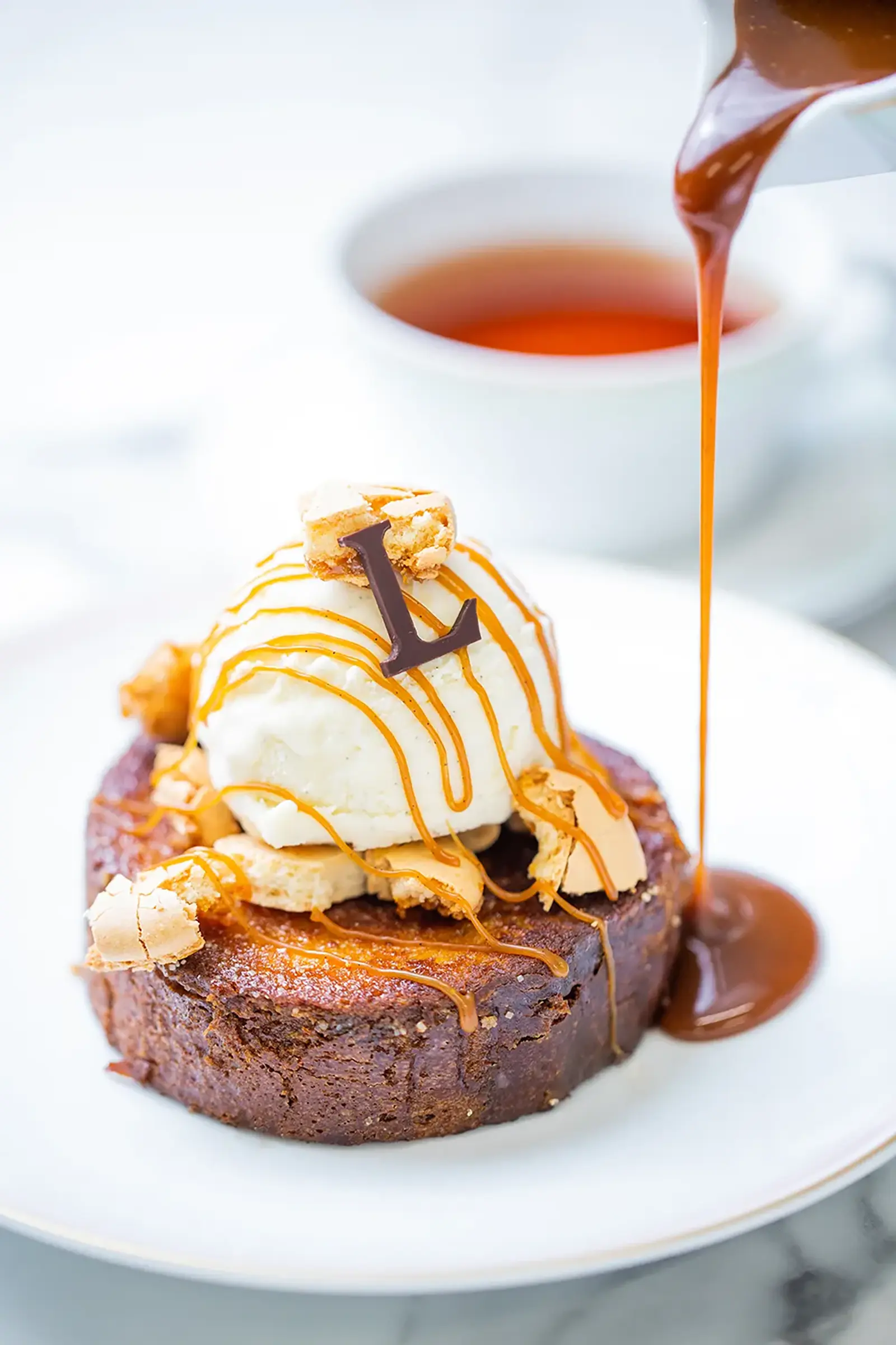 French toast topped with caramel sauce, vanilla ice cream, and macaron pieces.