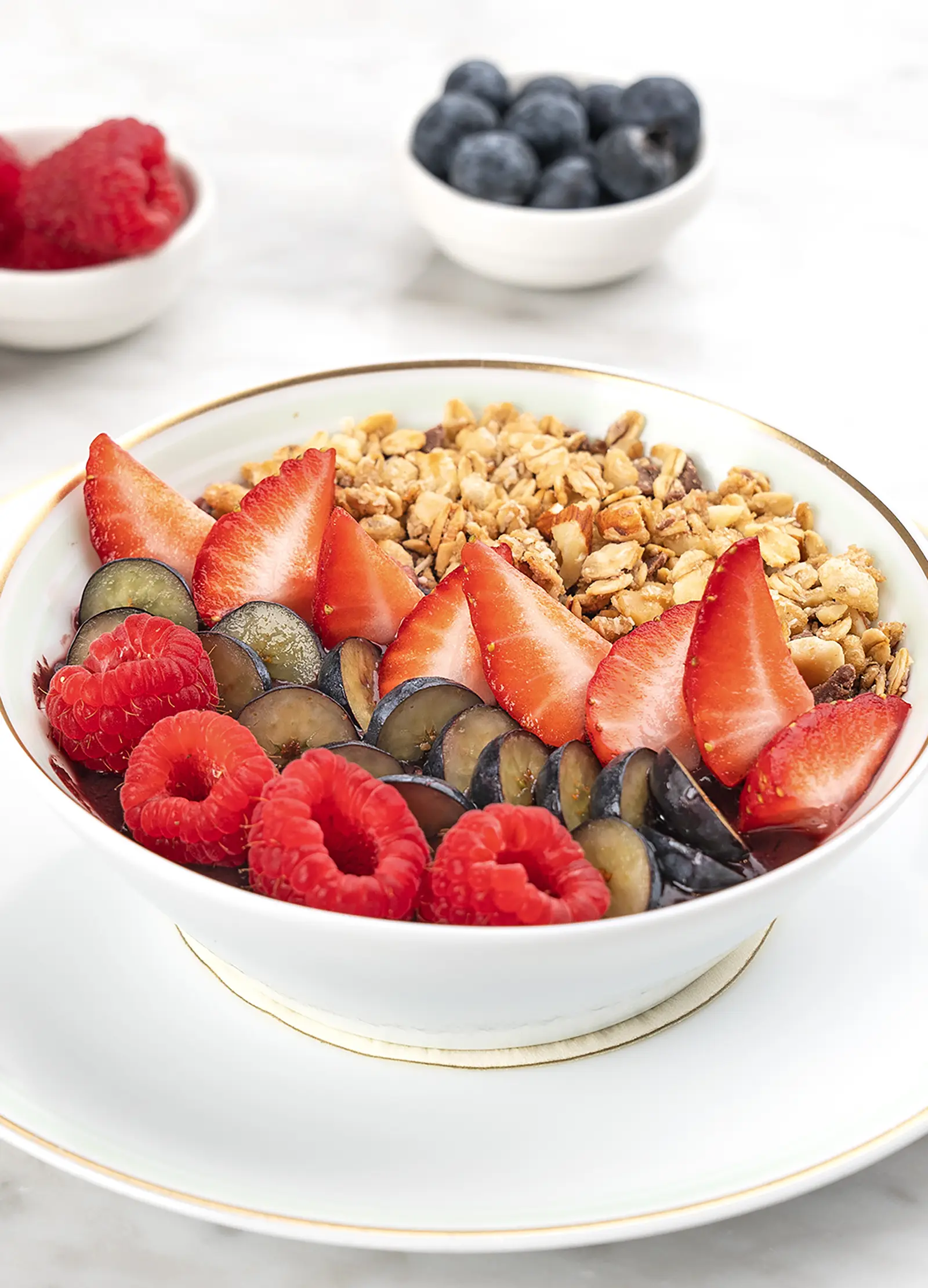 A colorful acai bowl topped with fresh fruit and granola.