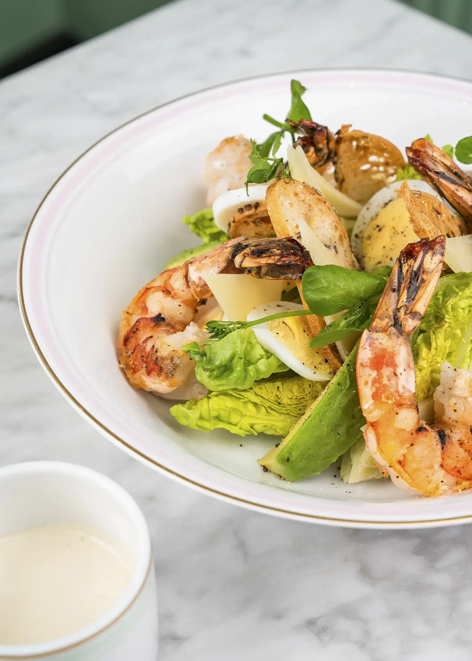 A Caesar salad with chicken, avocado, and parmesan.