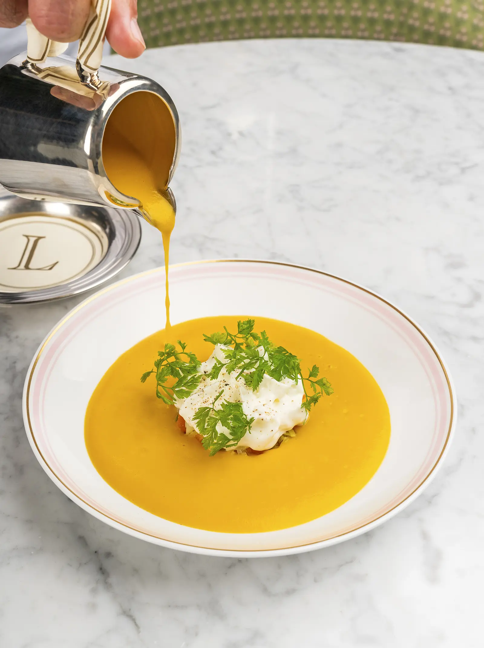 A bowl of hot vegetable soup with a drizzle of cream.