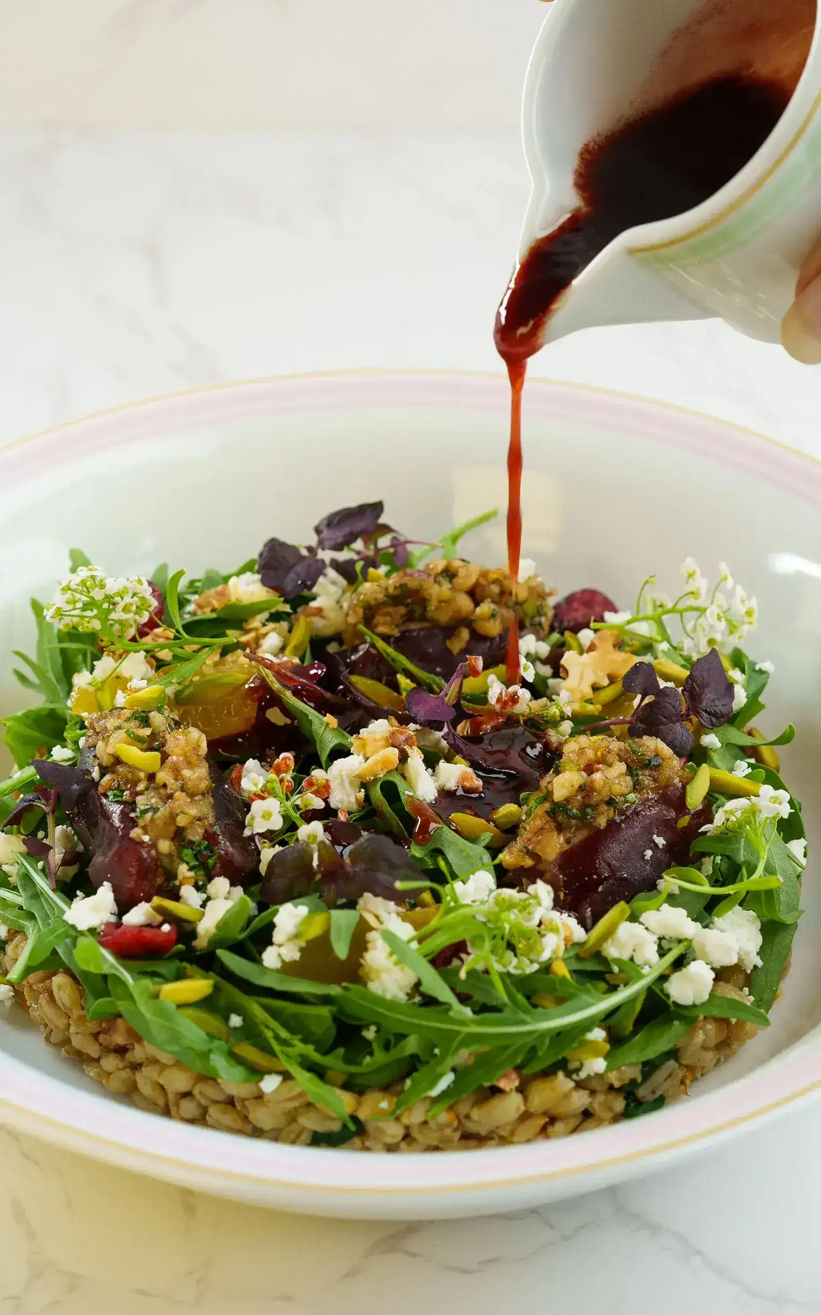 A salad with spinach, dates, and various nuts and cheese.