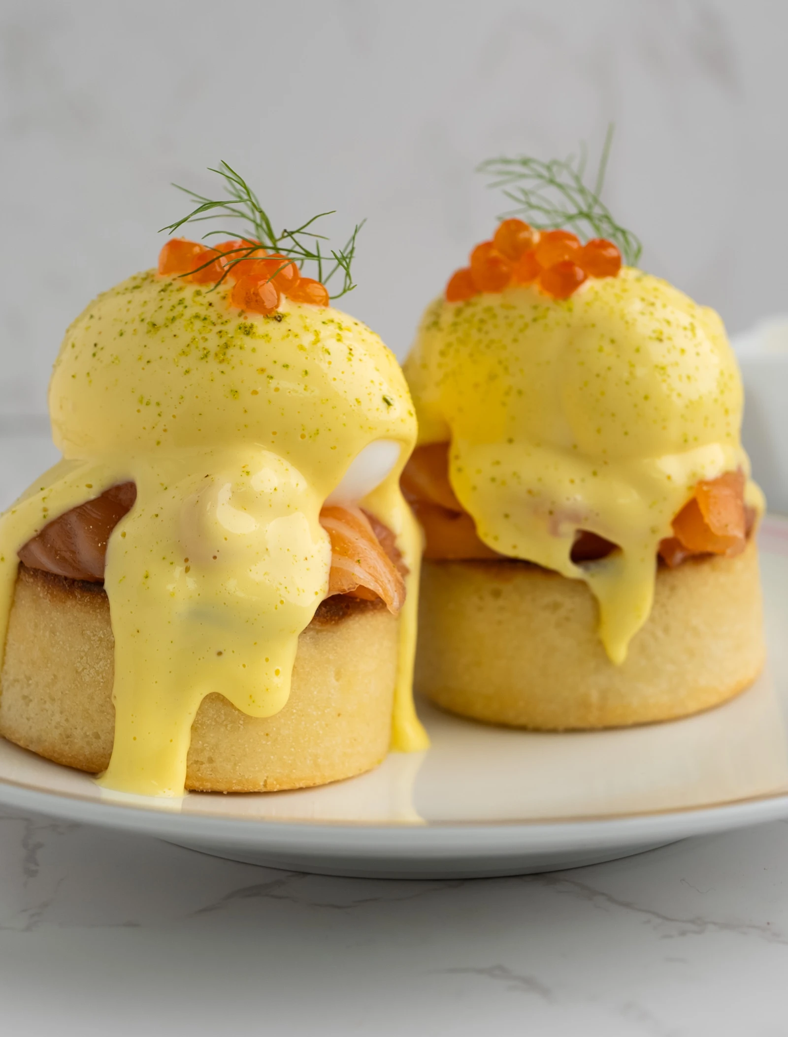 A dish of English muffins topped with smoked salmon and eggs.