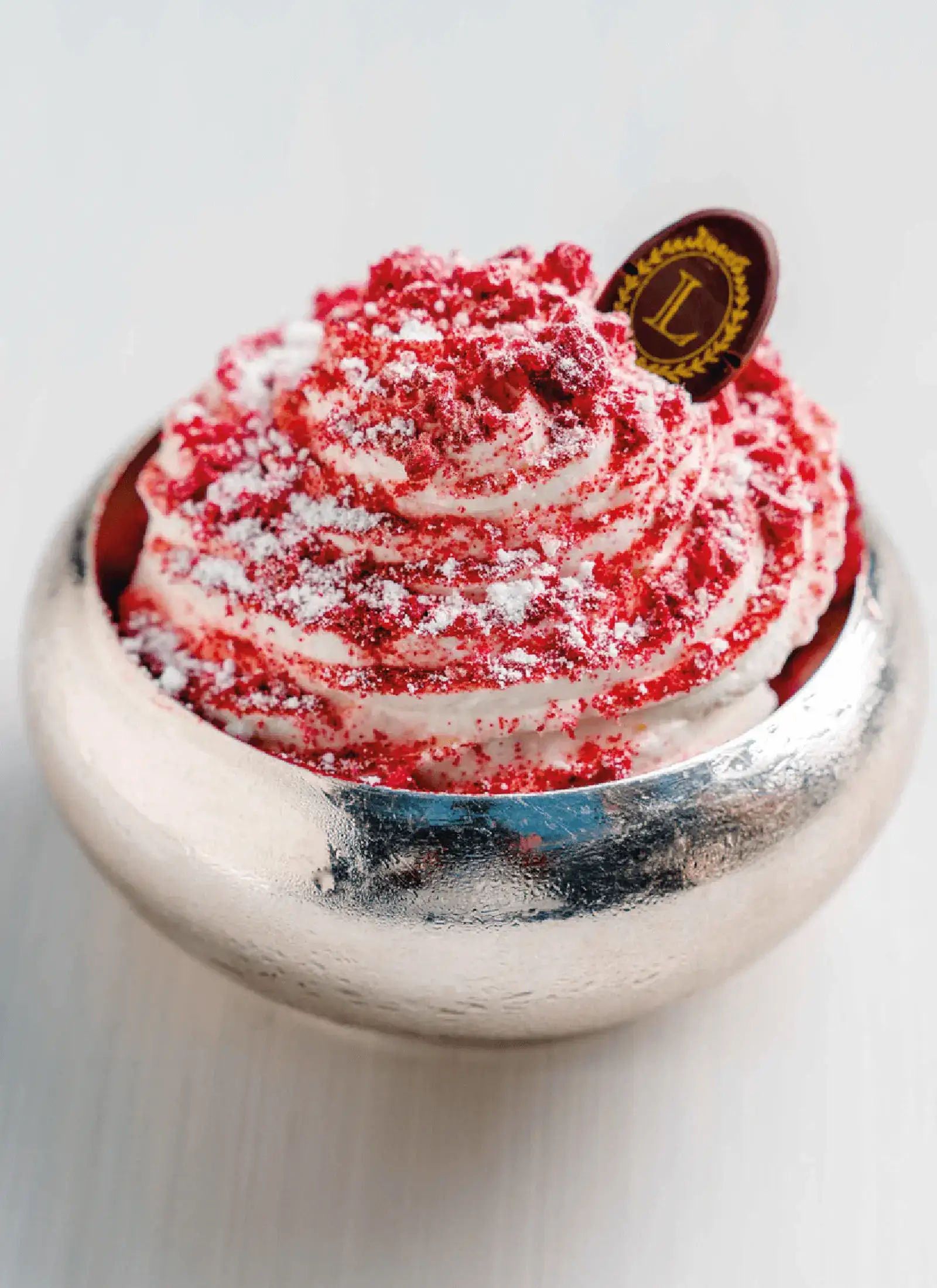 A cup of sorbet and ice cream with rose and raspberries.