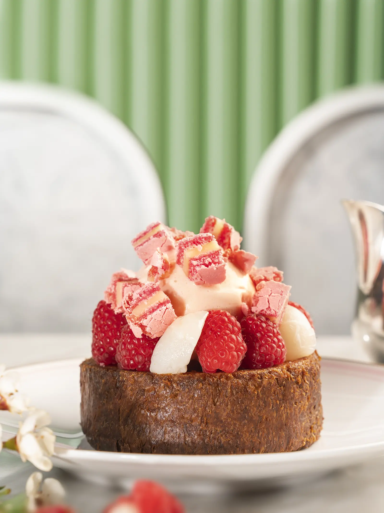 French toast topped with fresh raspberries, lychee, and a pink macaron.