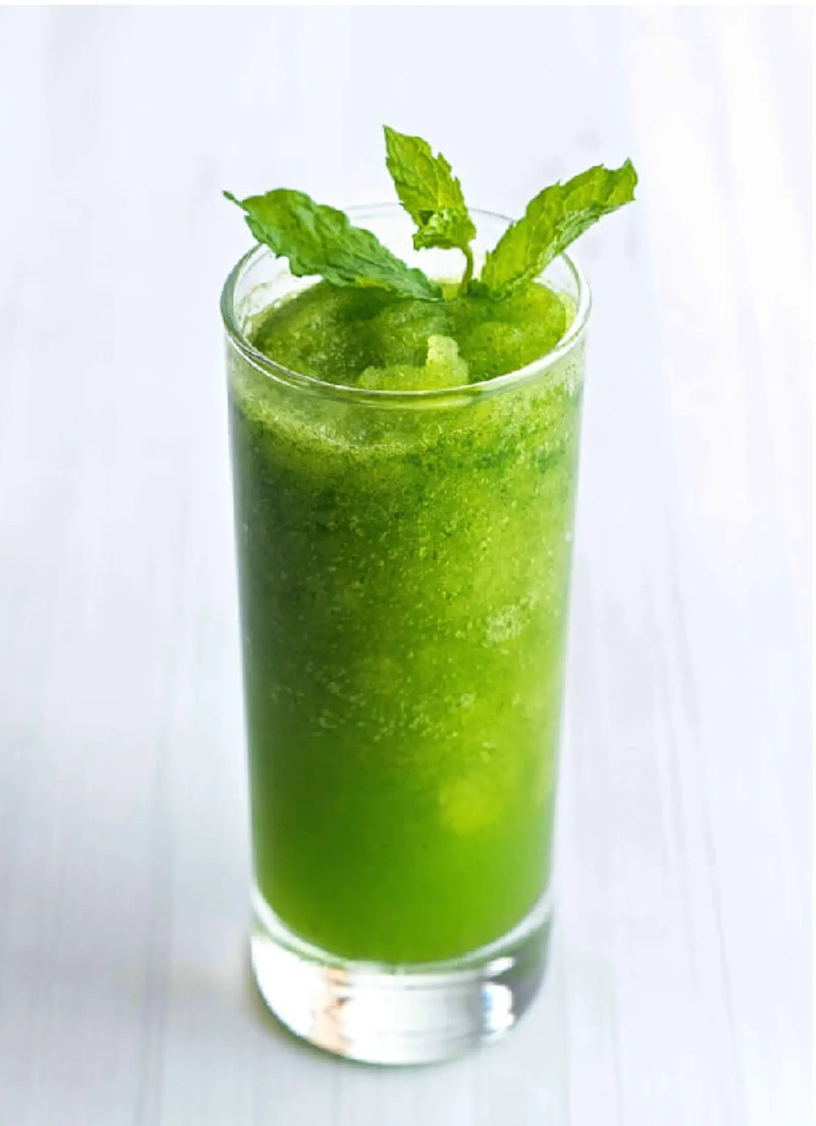 A glass of mint lemonade with a garnish of mint leaves and a lemon slice.