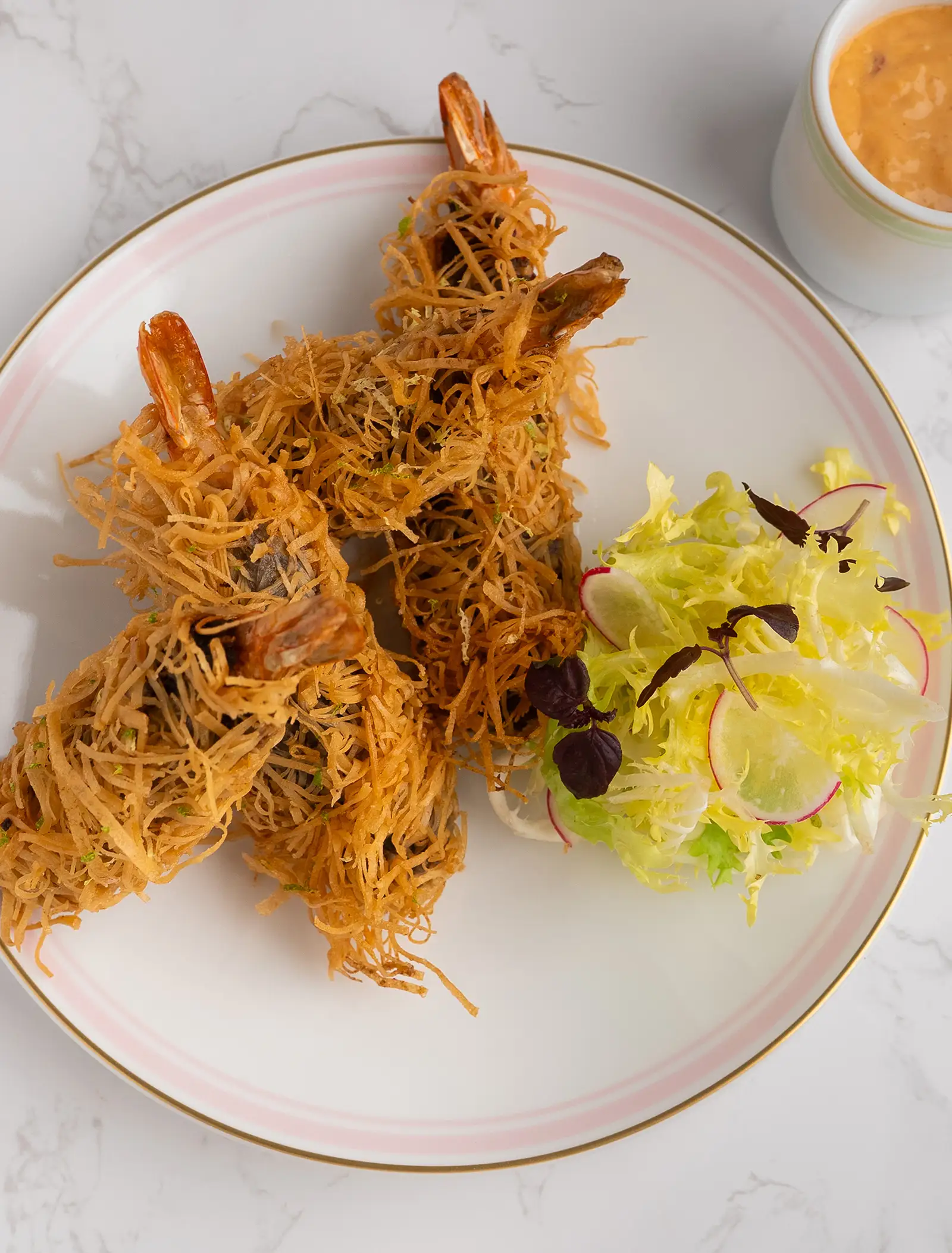 Shrimp rolls wrapped in crispy phyllo dough and served with a salad.