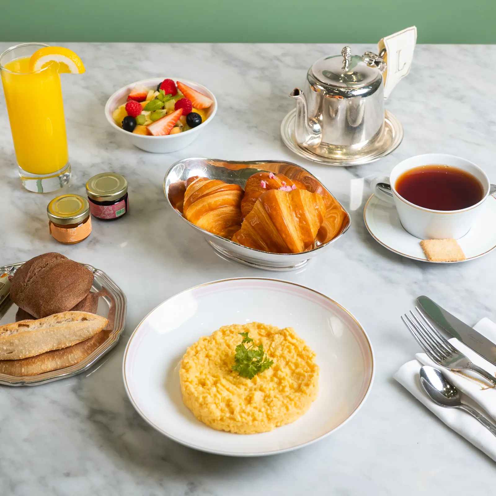 A breakfast tray with viennoiseries, coffee, and juice.