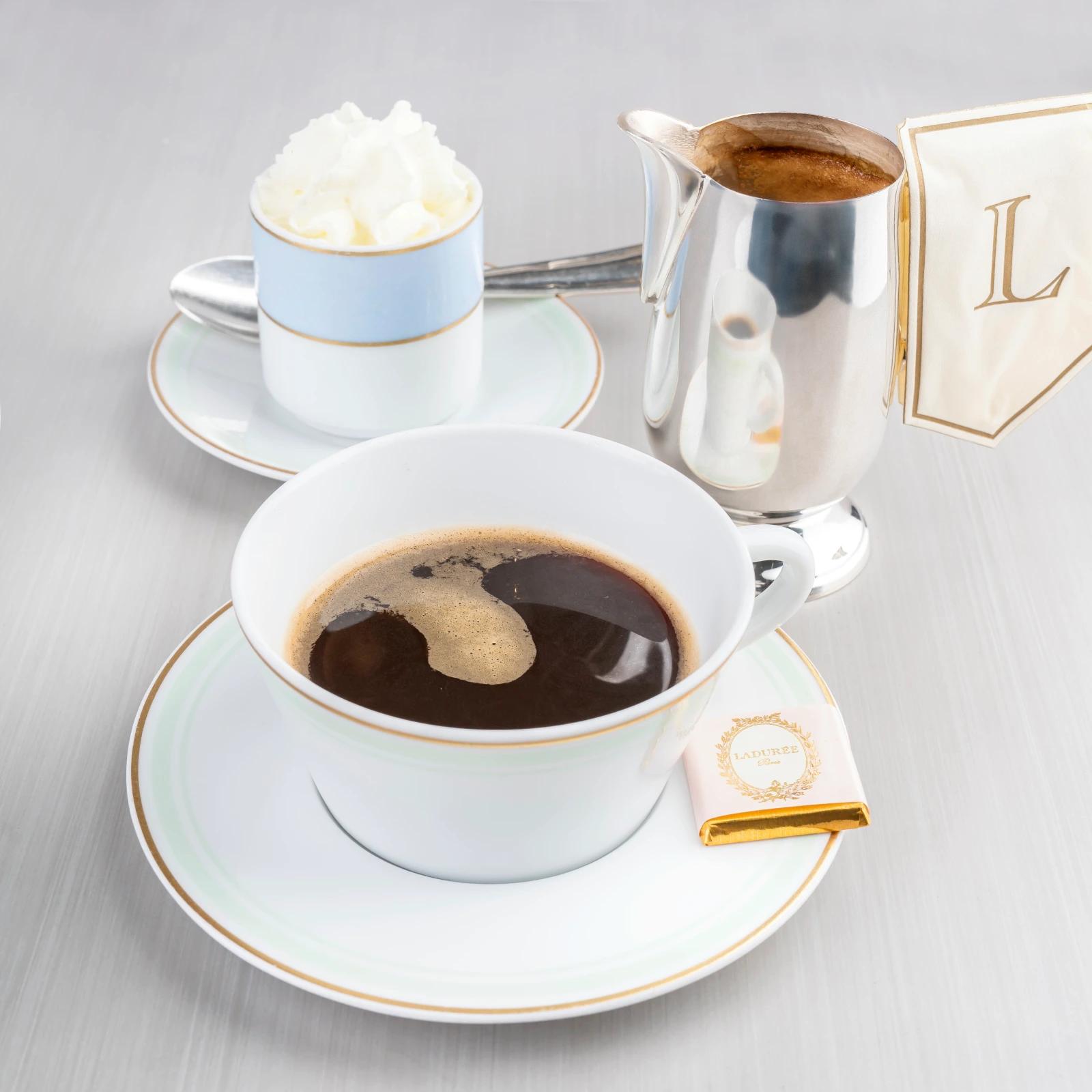 A cup of Ladurée coffee topped with a generous swirl of Chantilly cream.