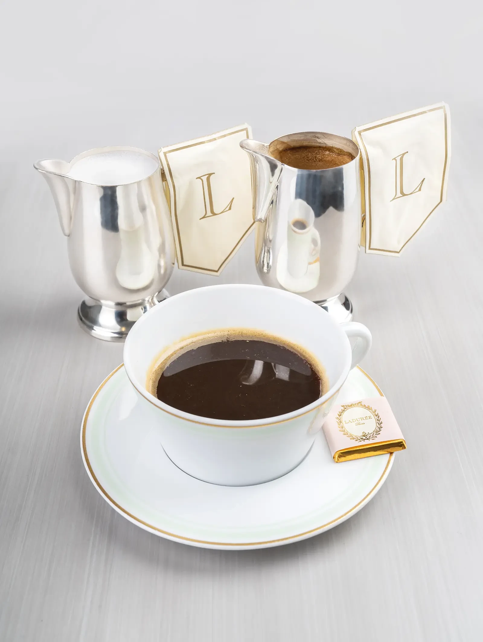 A cup of Ladurée coffee with a dash of milk.