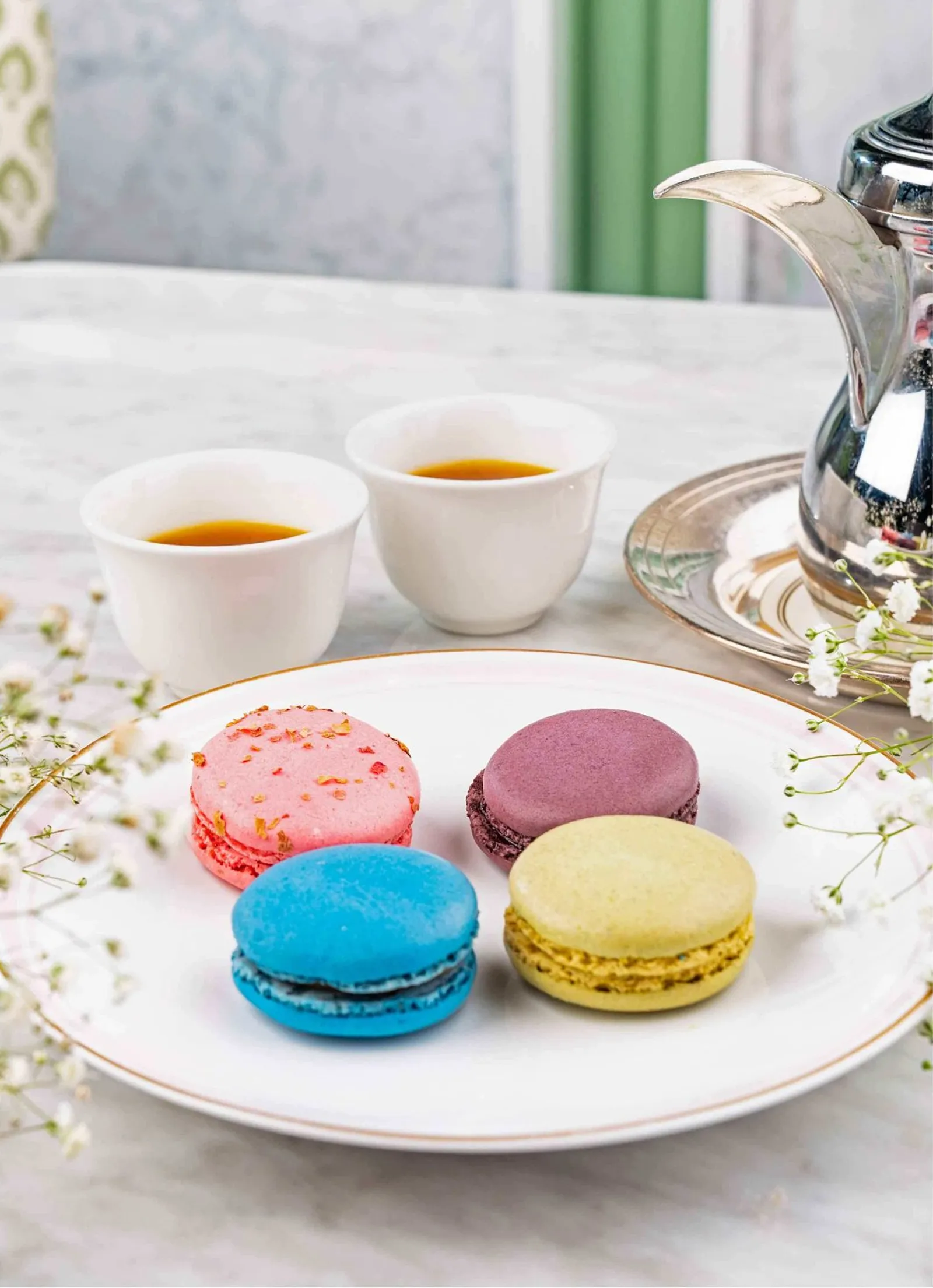 A small cup of Arabic coffee served with 4 macarons.