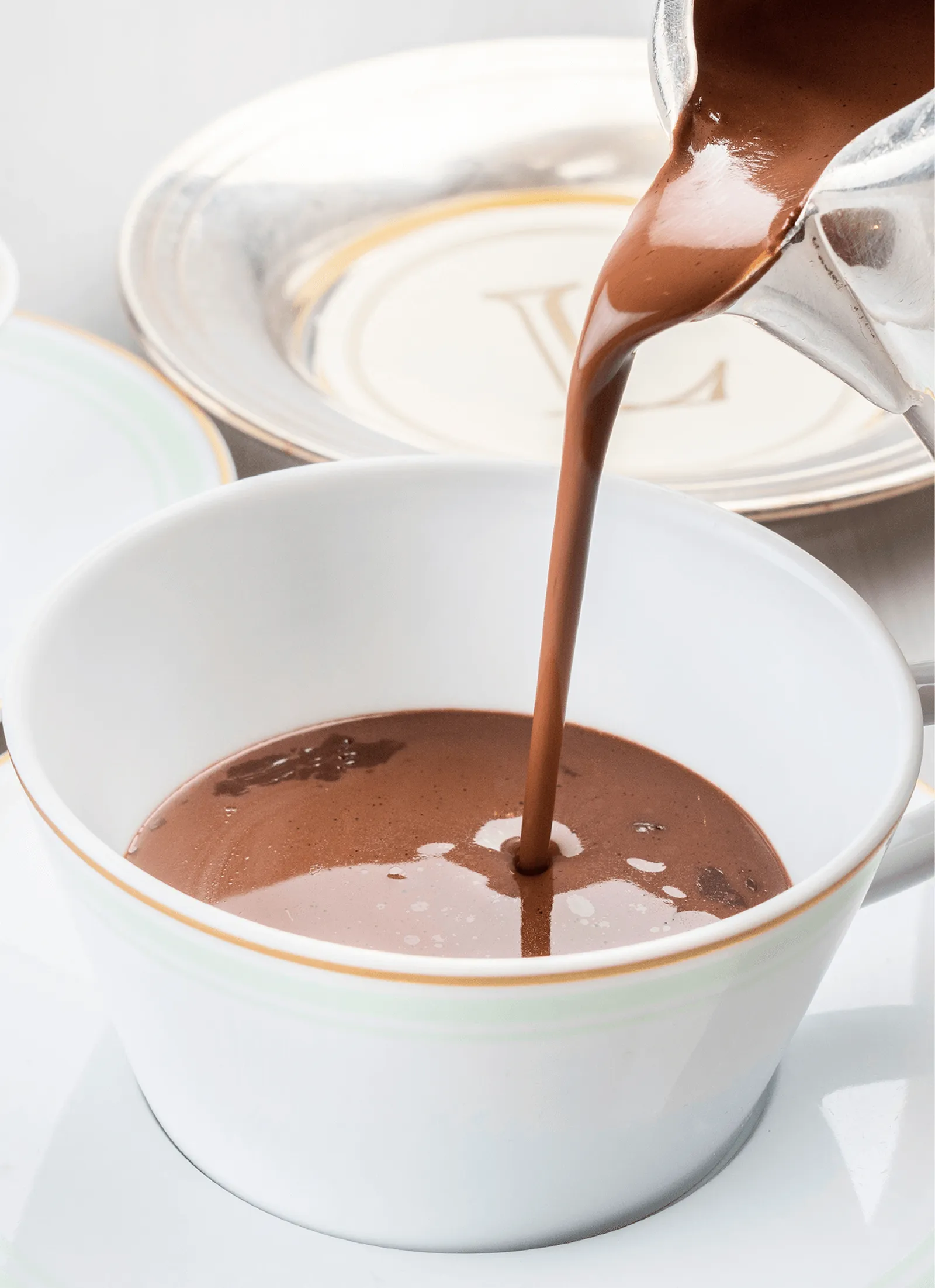 A cup of hot chocolate with a swirl of whipped cream on top.