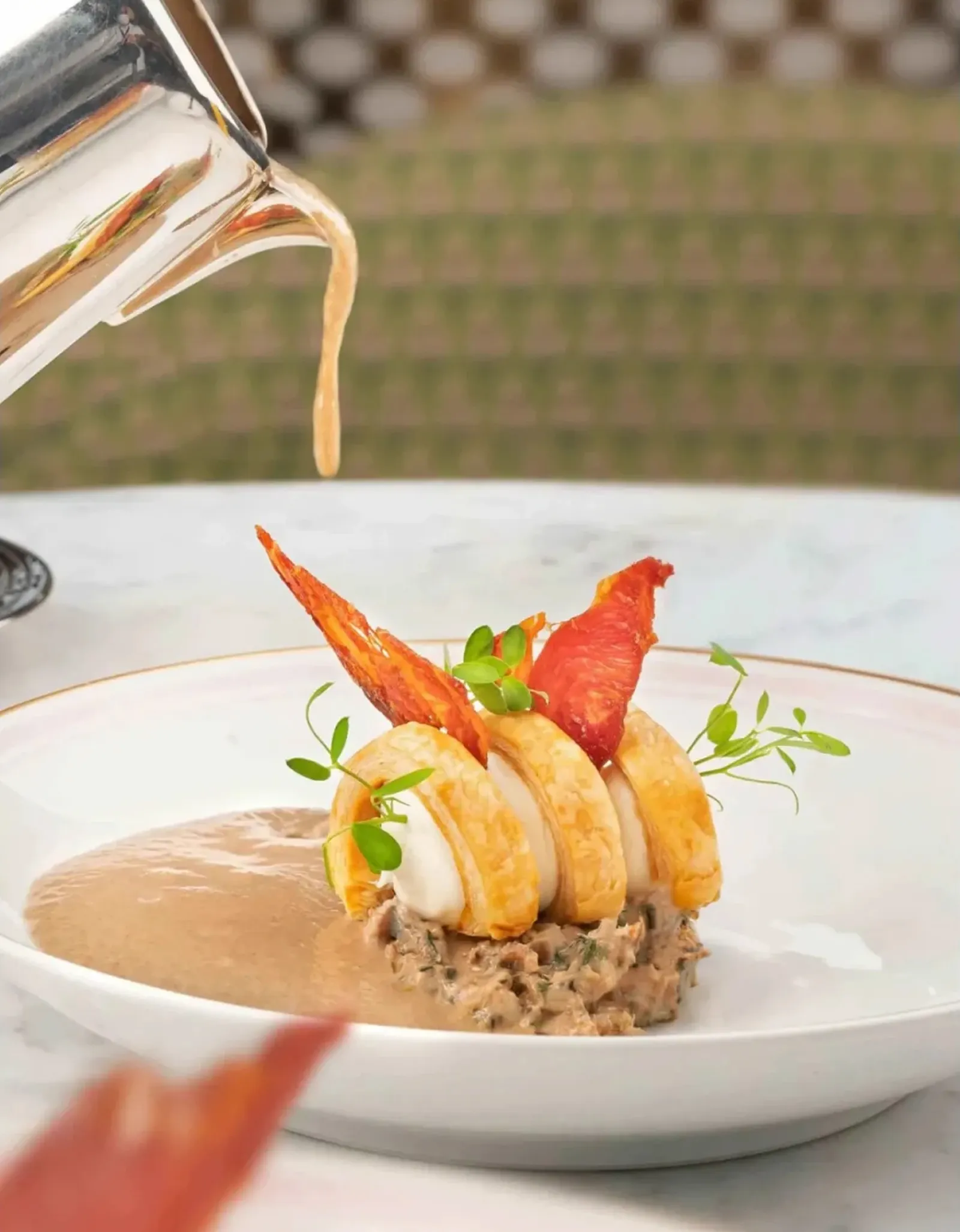 A bowl of creamy mushroom soup topped with a puff pastry lid.