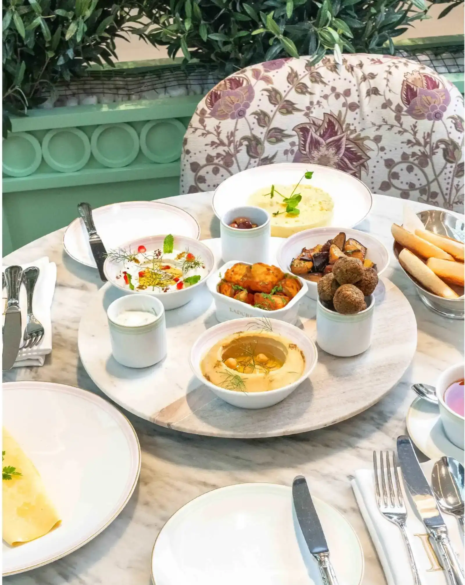 A spread of Middle Eastern breakfast dishes with eggs and tea.