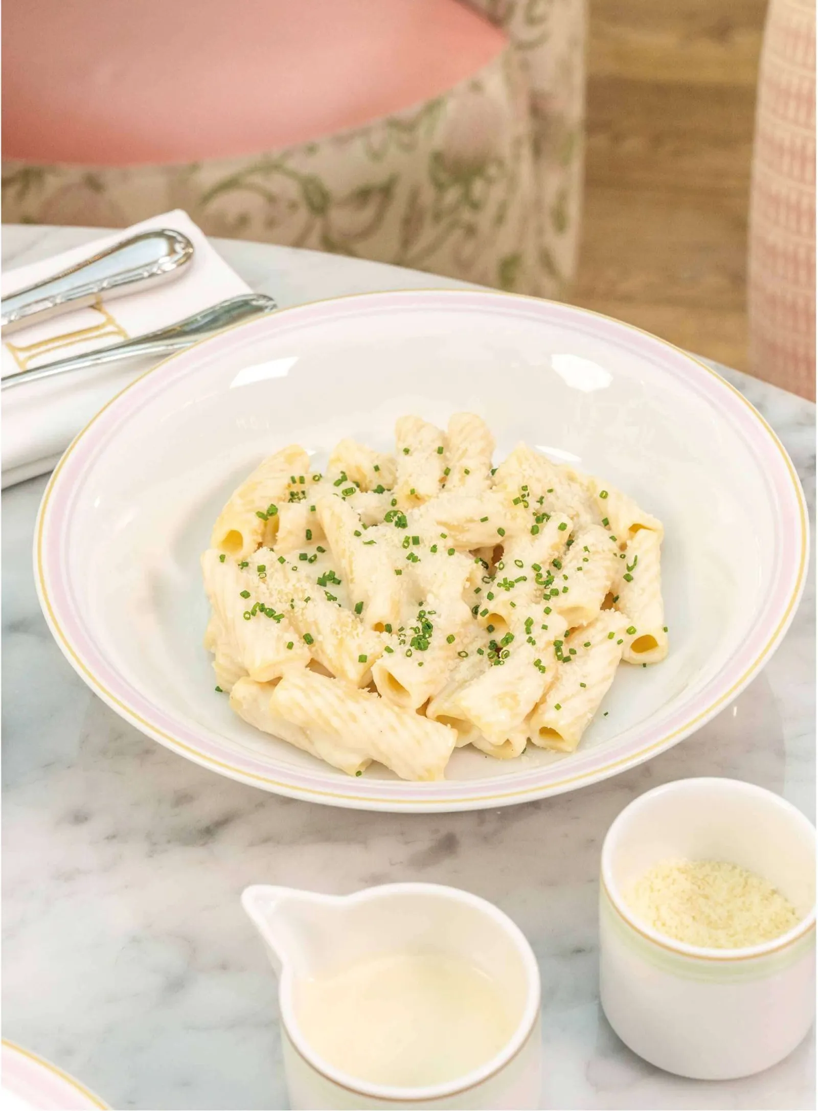 A bowl of rigatoni pasta with a creamy white sauce.